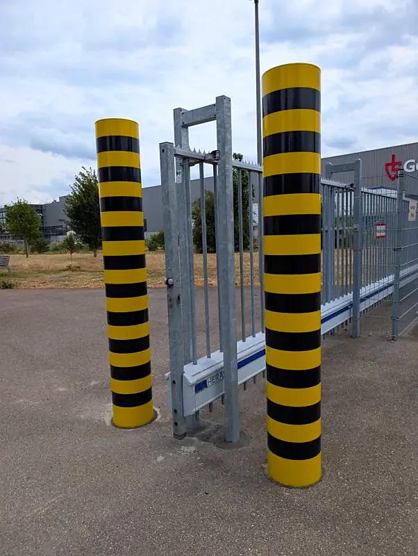 Zwei große Anfahrpoller gelb-schwarz an einer Werkszufahrt