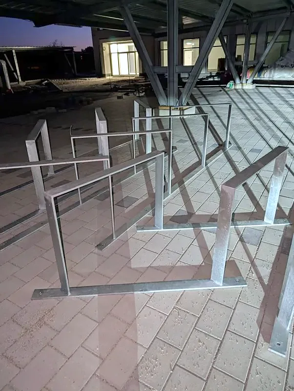 Reihe feuerverzinkter Fahrradbügel aus Flachstahl mit Fußplatte