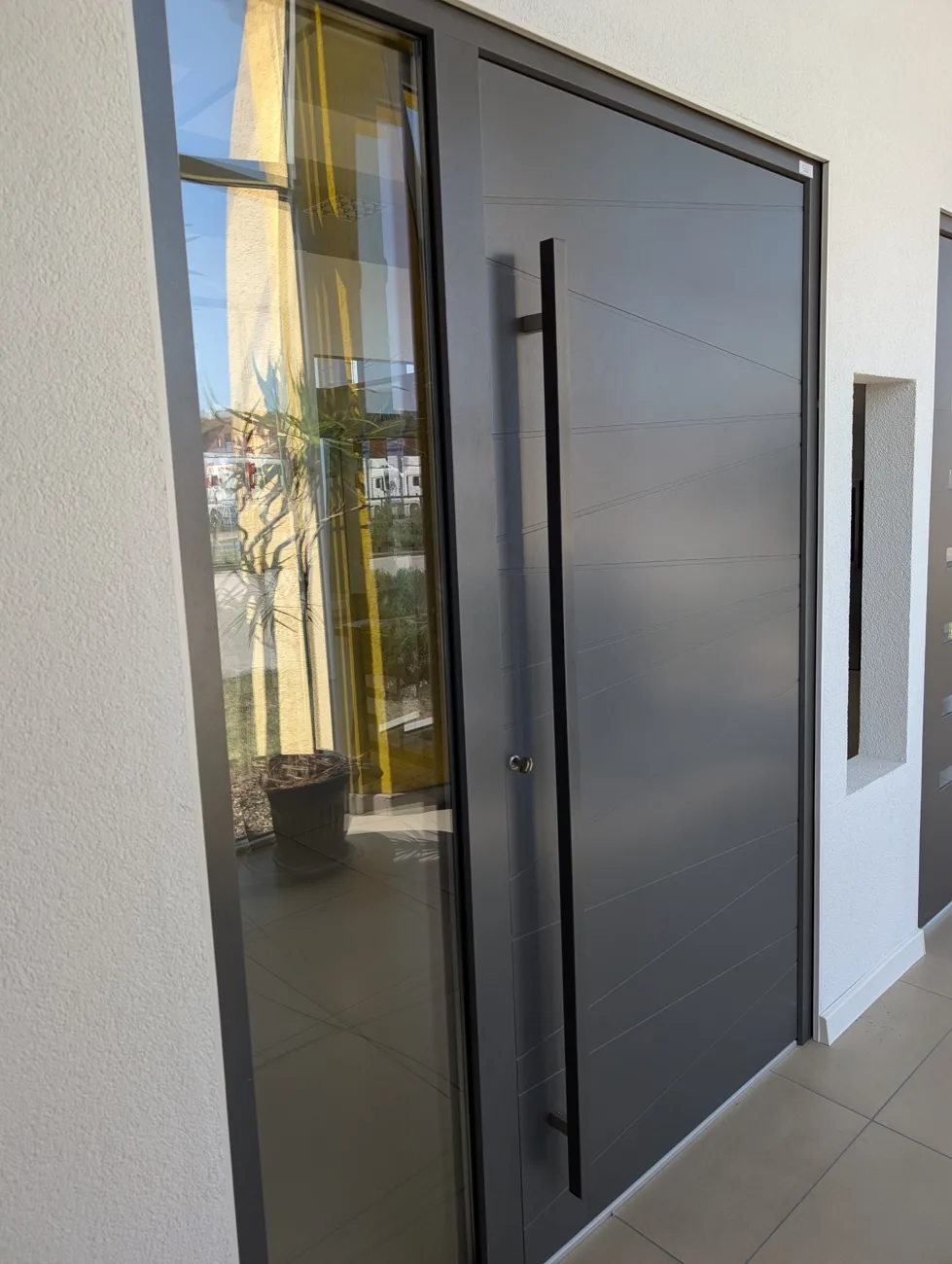 Haustür in Anthrazit mit langem Stoßgriff und Glas-Seitenteil