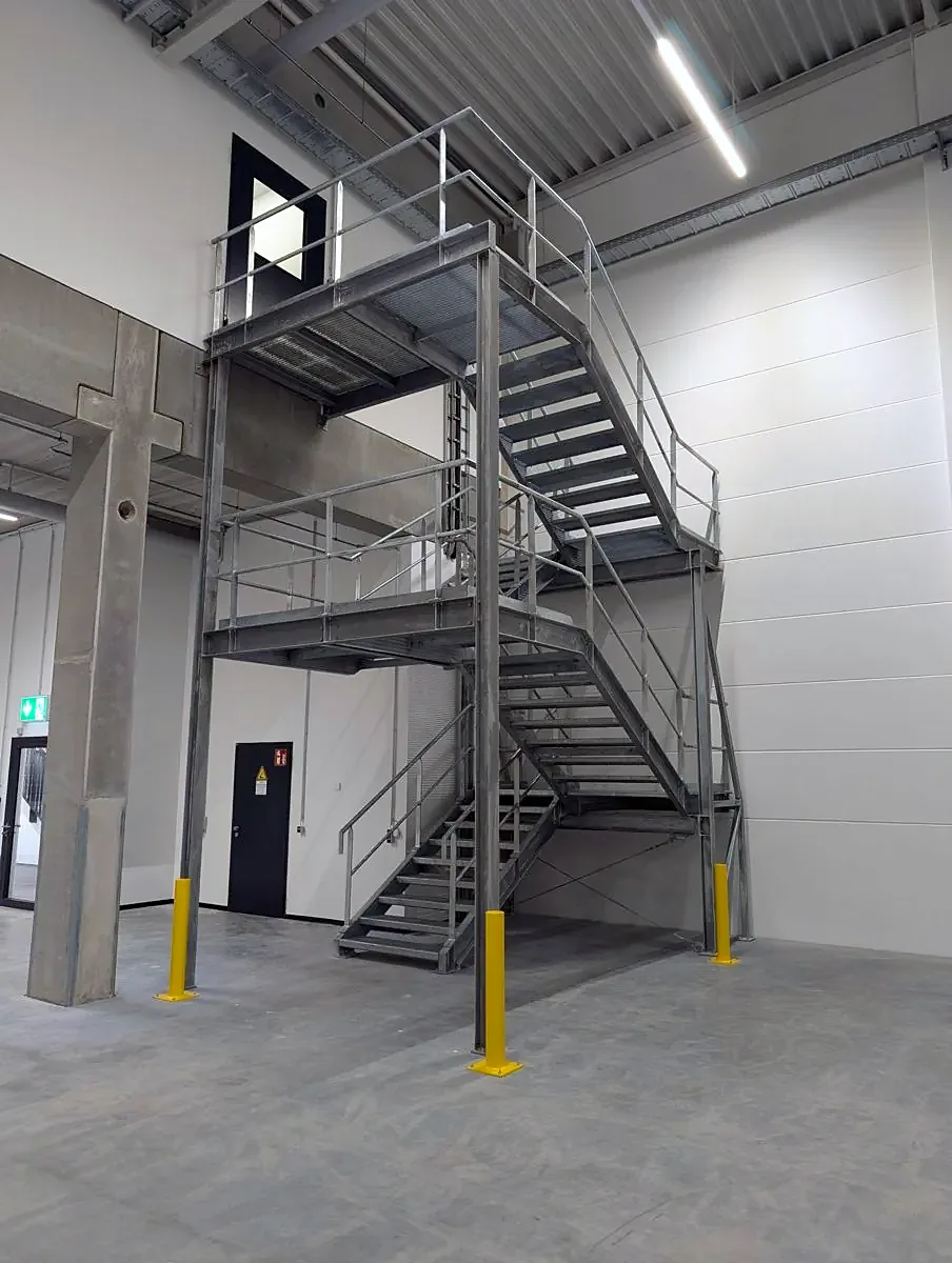Treppenturm aus feuerverzinktem Stahl mit zwei Podesten in einer Industriehalle